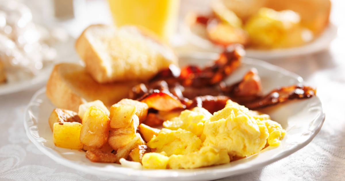 full breakfast with scrambled eggs, fried potatoes and bacon,